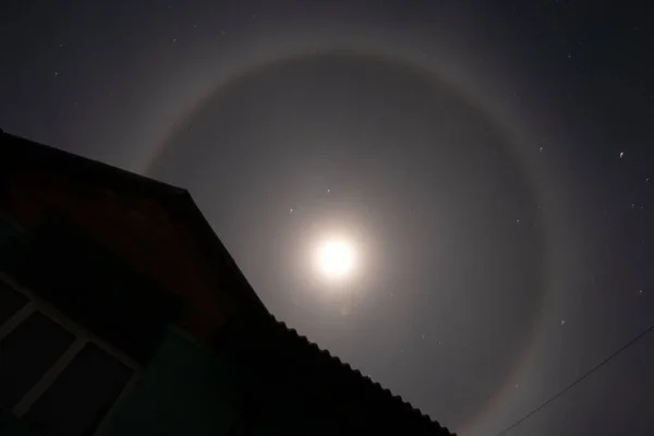 Halo phenomenon on the moon over Ukraine at night during the war in the country 2022, night moon and stars as a background