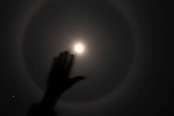 夜のウクライナ上空の月のハロー現象と少女の手2022 背景としての夜の月と星 — ストック写真