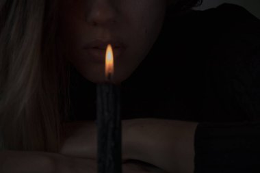 Genç bir Ukraynalı kız Ukrayna 'da bir mum için dua ediyor, bir kız karanlıkta yakın plan mumları döktü.