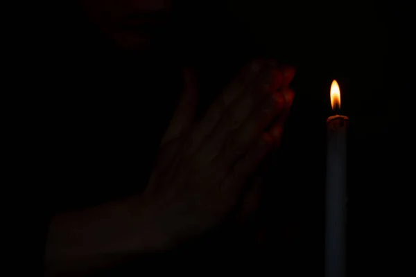 Mãos Uma Mulher Perto Chama Uma Vela Escuro Oração Pela — Fotografia de Stock