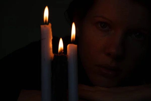 在乌克兰 一个年轻的乌克兰女孩在蜡烛旁边为乌克兰祈祷 一个女孩在黑暗的特写下了蜡烛 — 图库照片