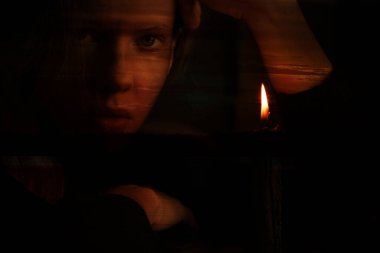 Bir kız Ukrayna 'daki Dinyeper Nehri' nde gün batımının arka planına mum alevi döktü. Ukrayna için bir dua, bir mum ve din.