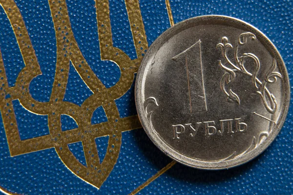Russian rubles and coat of arms of Ukraine close-up. Financial sanctions against Russia. The collapse of the ruble. Russian economy and ruble. Crisis in Russia 2022, the countrys economy — Stock Photo, Image