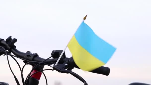 ウクライナの国旗 黄色と青は ウクライナの都市で風の中で自転車のハンドルバーに立って ウクライナでの戦争を停止し 自由人2022 — ストック動画