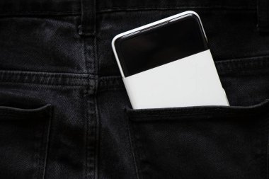 Ukrayna Dnipro 05.04.2022 - Yeni Samsung A52 akıllı telefonu beyaz bir çantada, gri pantolonun cebinde yatıyor, yeni aletler alıyor