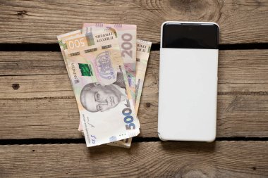 Ukrayna Dnipro 06.04.2022 Samsung A52 telefonu ve Ukrayna Hrivniası masada, akıllı telefon, iş ve finans üzerinden online ödeme