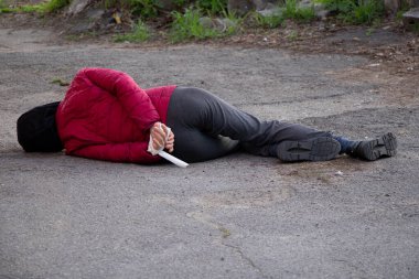 Ölü bir Ukraynalı kadın, elleri beyaz bir iple bağlanmış şekilde sokakta yatıyor ve Bucha 2022 'de Ukrayna' da bir ölüm protestosu sonucu öldürüldü.