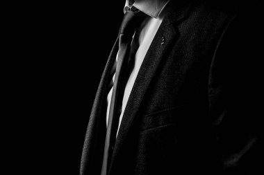 Siyah beyaz fotoğraflı, smokinli, takım elbiseli bir adam.