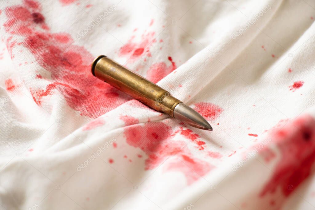 White women's dress in drops of blood and a bullet, a crime scene, a woman's murder, blood on clothes