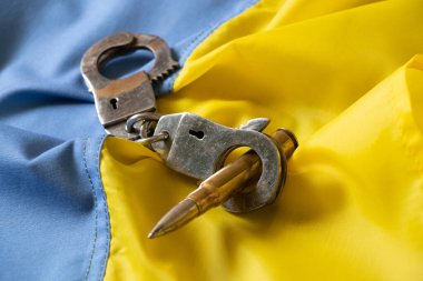 Kelepçe ve kurşun Ukrayna 'nın sarı-mavi bayrağında, Ukrayna' da yasalar, demokrasi ve Ukrayna 'da savaş, iç savunma