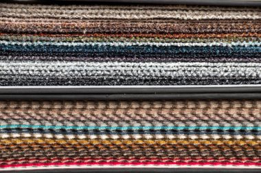 Müşterinin döşeme seçimi için farklı renk kumaş kataloğu, arka plan olarak çok renkli kumaş örnekleri, atölyedeki moda trendi kumaşları