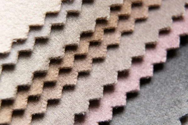 Müşterinin döşeme seçimi için farklı renk kumaş kataloğu, arka plan olarak çok renkli kumaş örnekleri, atölyedeki moda trendi kumaşları