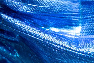 Arka plan makro fotoğrafı olarak parlak mavi kumaş, şenlikli ambalaj