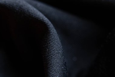 Arkaplan olarak bir dalga, siyah arkaplan, moda ve doku olarak siyah yumuşak kumaş