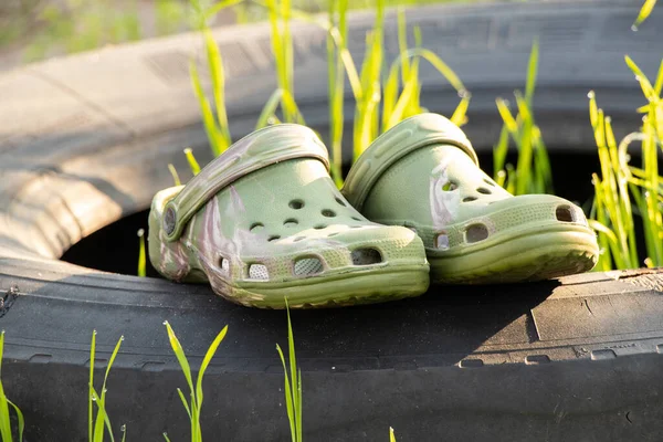 Plastic summer shoes for water and leisure, camouflage on the wheel from the car in the summer in the sun, beach shoes, fashion trend shoes