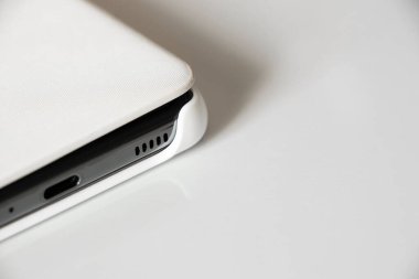 Beyaz telefon beyaz arka planda, yakın planda, akıllı telefon ise yakın planda.
