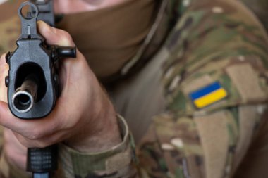 A Ukrainian soldier in military uniform holds a machine gun, the war in Ukraine and the protection of his home and family 2022