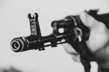 Askeri üniformalı bir Ukraynalı asker bir makineli tüfek, Ukrayna 'daki savaş ve 2022 yılında evinin ve ailesinin korunması tutuyor.
