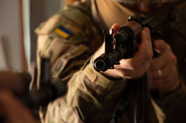 Askeri üniformalı bir Ukraynalı asker bir makineli tüfek, Ukrayna 'daki savaş ve 2022 yılında evinin ve ailesinin korunması tutuyor.