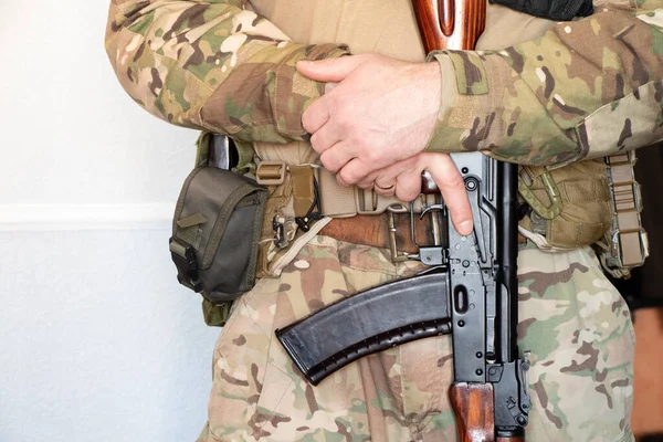 Askeri üniformalı bir Ukraynalı asker bir makineli tüfek, Ukrayna 'daki savaş ve 2022 yılında evinin ve ailesinin korunması tutuyor.
