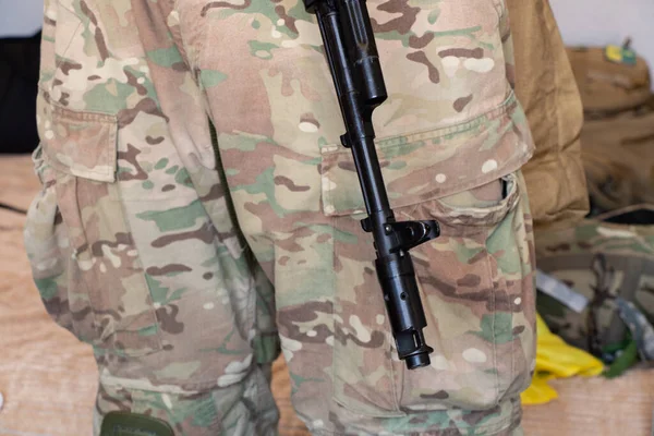 Askeri üniformalı bir Ukraynalı asker bir makineli tüfek, Ukrayna 'daki savaş ve 2022 yılında evinin ve ailesinin korunması tutuyor.