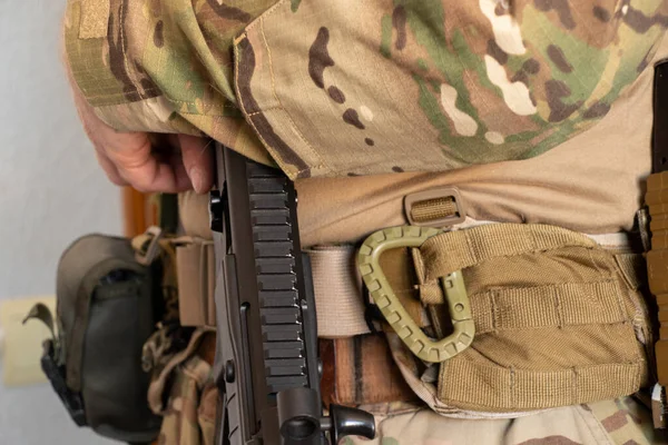 Askeri üniformalı bir Ukraynalı asker bir makineli tüfek, Ukrayna 'daki savaş ve 2022 yılında evinin ve ailesinin korunması tutuyor.