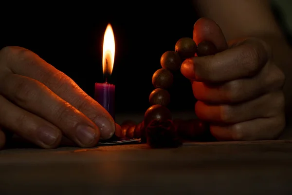 暗闇の中で木製のロザリオと聖書の嘔吐キャンドルを持つ女性 女性が祈る 信仰と宗教 — ストック写真