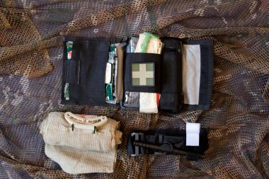 Ukraine Dnepr 09.05.2022 - The first aid kit of a military soldier in Ukraine in the war lies on a camouflage net, an ambulance