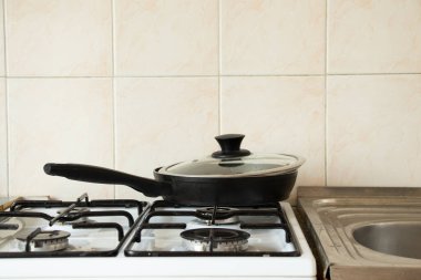 Kızartma tavası mutfaktaki gaz sobasının üzerinde duruyor mutfak gereçleri ve ev aletleri, yemek pişirme.