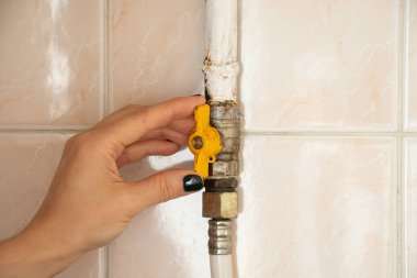 El, gaz borusunun musluğunu evdeki fayansların arka planına, mutfaktaki gaz borusunun musluğuna kapatır.