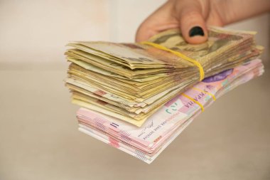 Bir kadının elinde bir yığın Ukrayna hryvniası var, para veriyor, elinde yüz iki yüz hryvnia.