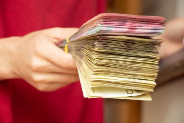 Bir kadının elinde bir yığın Ukrayna hryvniası var, para veriyor, elinde yüz iki yüz hryvnia.