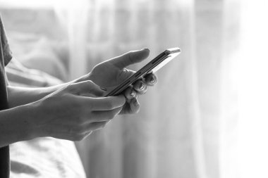 Kız evde bir telefon tutuyor, telefonla iletişim kuruyor, cep telefonuyla görüşme yapıyor.