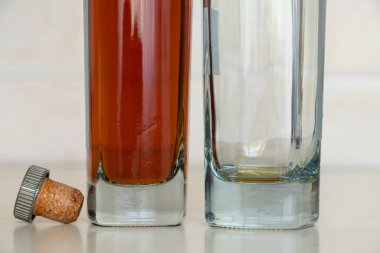 İki şişe, bir tane boş konyak ve mutfaktaki masada bir mantar, evdeki masada alkol, bir şişe konyak.