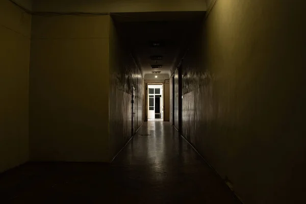 An old dark corridor is long in an office building in the city center in Ukraine, a door to the corridor, an exit, a building and an interior