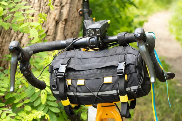 The flag of Ukraine is tied to the handlebars of a sports bike on the street of Ukraine, a bicycle bag on the handlebars, urban transport, cycling in Ukraine