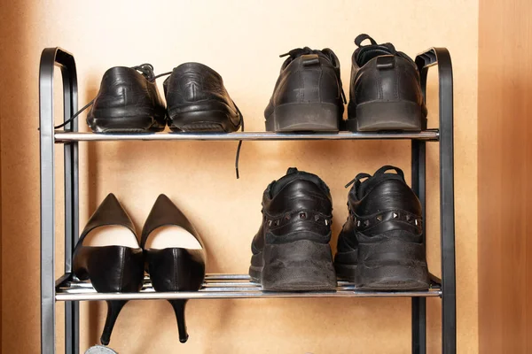 A shelf with shoes in the closet, sneakers, sneakers and shoes are on the shelf in the hallway, womens worn shoes, a pair of old shoes