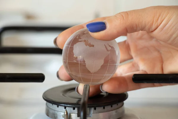 Woman Hand Holds Small Ball Earth Gas Burner Home Global — Stockfoto