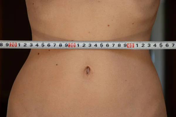 A centimeter at the waist of a slender young girl, diet and weight loss, girl\'s belly