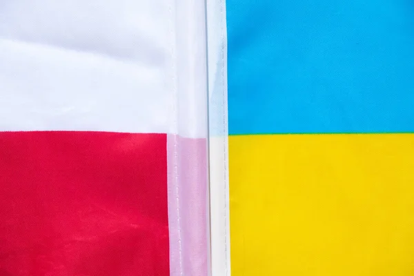 The flag of Poland and the flag of Ukraine as a background, an alliance between the two countries during the war in Ukraine