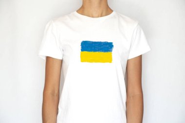 A girl in a white T-shirt with a painted flag of Ukraine on a white background, patriotism