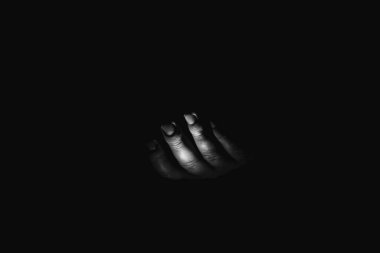 Male hand in the dark, black and white photo, fear and horror, a hand asking for help