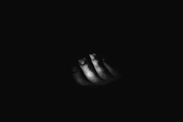Male hand in the dark, black and white photo, fear and horror, a hand asking for help