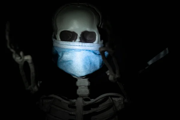 Skull in a medical mask in the dark, medicine and healthcare, flu death