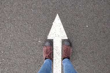 Kadınların ayakları yolda ön oklarda, spor ayakkabılar yolda ve yol ileri oklarda durur, başla ve başla