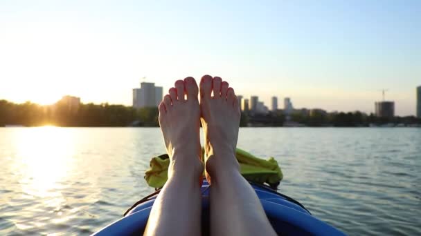 2022の戦争中にウクライナのドニプロ市の日没を背景にカヌーの中の女性の足 — ストック動画