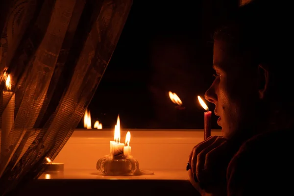 在乌克兰的一个没有电的公寓里 女孩的脸上挂着蜡烛 因为战争 一个没有灯的公寓 — 图库照片