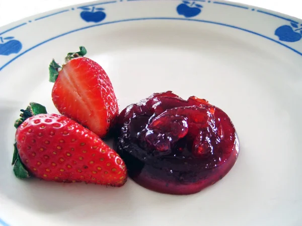 Полуничне варення з двома полуницями на тарілці — стокове фото