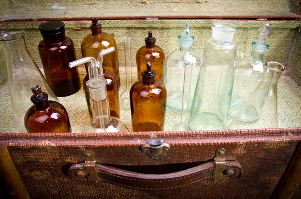 Винтажный чемодан с химическими колбами и банками — стоковое фото