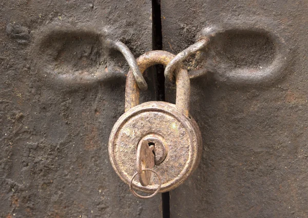Velho cadeado enferrujado em uma porta de ferro closeup — Fotografia de Stock
